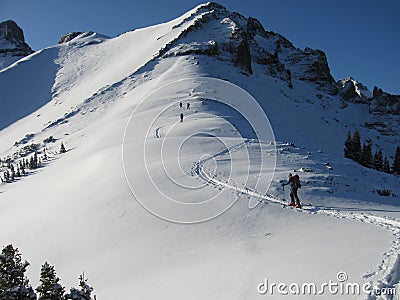 People hiking through snow to the mountain peak Stock Photo