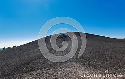 People hiking to the top of Inferno Cone at Craters of the Moon National Park Stock Photo