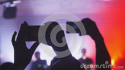 People hold smart phone and records concert. Crowd partying at a concert or a night club. Stock Photo