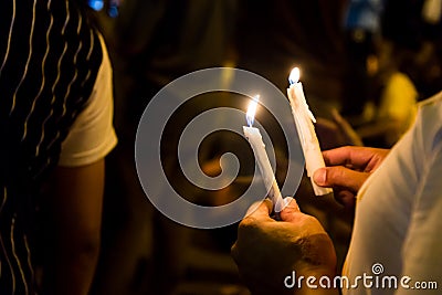 People holding candle vigil in darkness seeking hope, worship, p Stock Photo