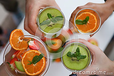 People holding glasses with bright fruit drinks Stock Photo