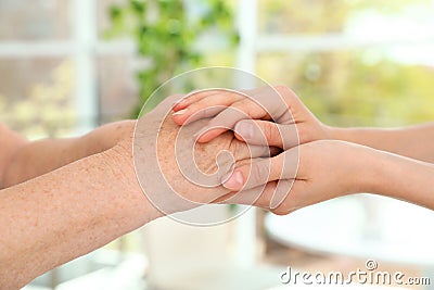 People holding hands together on blurred background. Help and elderly care concept Stock Photo