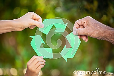 People holding recycle symbol against green spring background Stock Photo