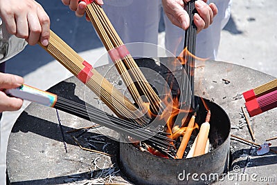 People ignite bundles of incense sticks Stock Photo