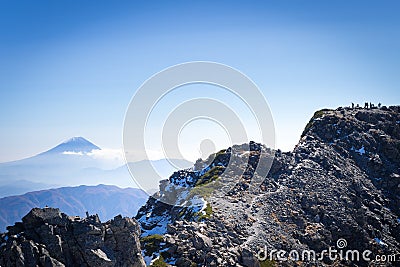 People on Kitadake peak taking rest and looking at Mt.Fuji Stock Photo