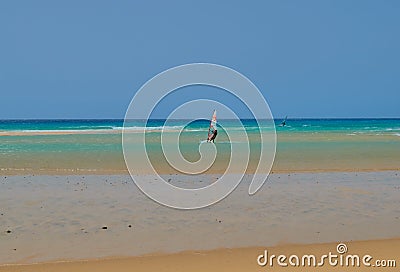 People learning to surf on a beach with waves and turquoise water in Fuerteventura Editorial Stock Photo