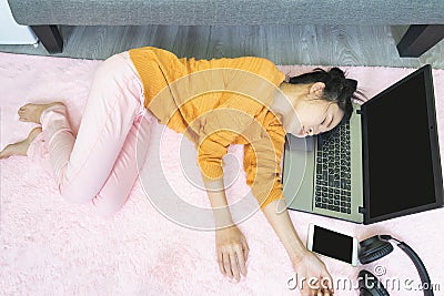 People and leisure concept.Asian young woman working from home under quarantine using a laptop, tired, fatigued,sleepy and falls Stock Photo