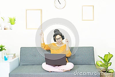 People and leisure concept - happy smiling asian young woman with laptop having fun, resting on weekends at home under quarantine Stock Photo