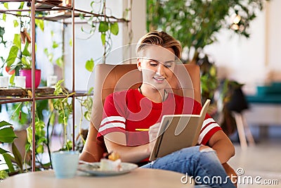 Teenage girl with notebook at coffee shop or cafe Stock Photo