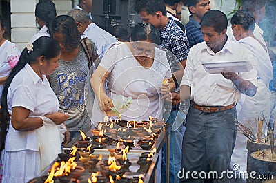 People light candles at the Buddhist temple during Vesak religious celebration in Colombo, Sri Lanka. Editorial Stock Photo