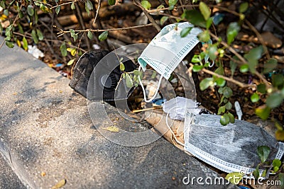 People littering of garbage of used medical masks throw in the crevices of the bushes,hazardous waste,risk of disease,spread of Stock Photo