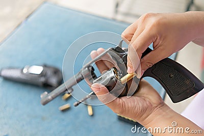 People load bullets into revolver gun Stock Photo