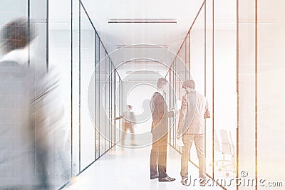 People in a long office corridor with glass walls. There are several conference rooms in it and. Stock Photo