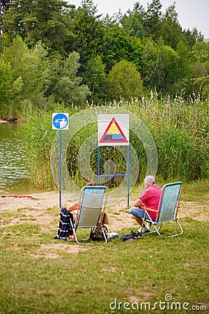 People lying in a comfortable lawn chair on a sunny beach Editorial Stock Photo