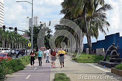 People with masks walking on bay walk to view the artificially face lifted beach coast line dumped with white dolomite sand Editorial Stock Photo