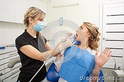 People, medicine, stomatology and health care concept - happy female dentist with mirror checking patient girl teeth up Stock Photo