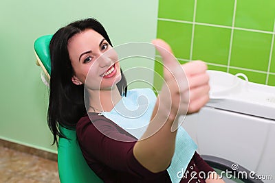 People, medicine, stomatology and health care concept - happy patient girl showing thumbs up at dental clinic office Stock Photo