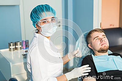 People, medicine, stomatology and healthcare concept - happy young female dentist with tools over medical office Stock Photo