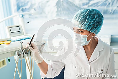 People, medicine, stomatology and healthcare concept - happy young female dentist with tools over medical office Stock Photo