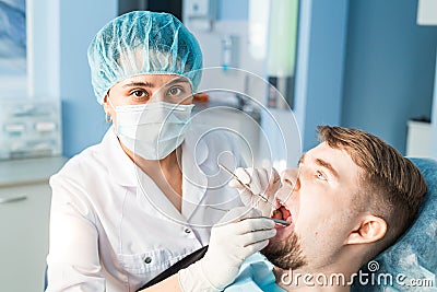 People, medicine, stomatology and healthcare concept - happy young female dentist with tools over medical office Stock Photo