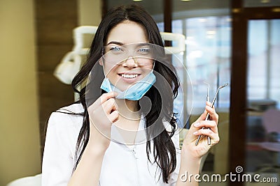 People, medicine, stomatology and healthcare concept - happy young female dentist with tools over medical office background Stock Photo