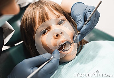 People, medicine, stomatology, technology and health care concept. Male dentist working with little girl in clinic. Stock Photo