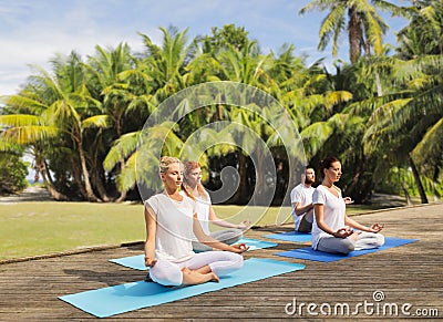 People meditating in yoga lotus pose outdoors Stock Photo