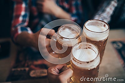 People, men, leisure, friendship and celebration concept - happy male friends drinking beer and clinking glasses at bar or pub Stock Photo