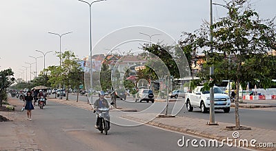 People on mopeds ride on a city street. Typical traffic in an Asian city. City life Editorial Stock Photo