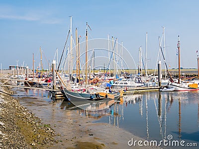 People, motorboats and sailboats in marina of West Frisian island Schiermonnikoog, Netherlands Editorial Stock Photo