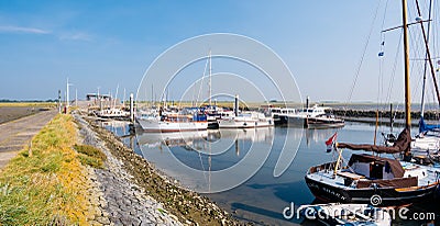 People, motorboats and sailboats in marina of West Frisian island Schiermonnikoog, Netherlands Editorial Stock Photo