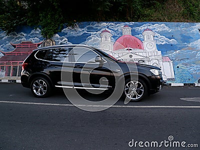 People move through the road with the mural of Semarang's cultural icon located on the Sumbing road. Editorial Stock Photo