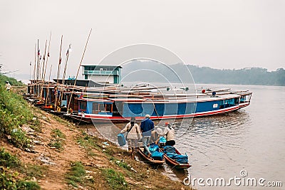 People Moving Commodities to The Land by Boat in The River at Luang Prabang, Laos Editorial Stock Photo