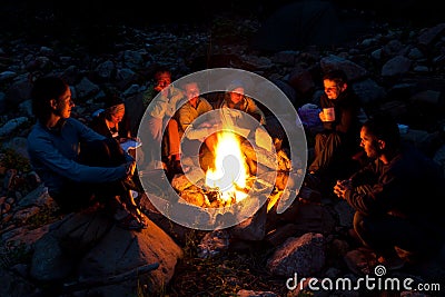 People near campfire in forest Stock Photo