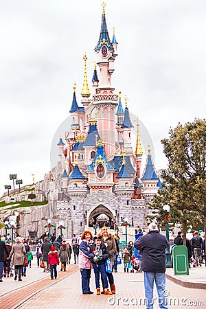 People near castle in the Disneyland Paris are taking photo. Editorial Stock Photo