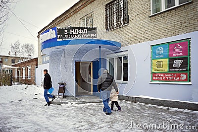 People are near the entrance to the district tax department with an electronic sign with the inscription in Russian Editorial Stock Photo
