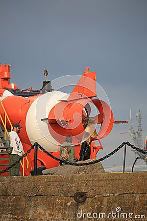 People near the stern of old deep-submergence rescue vehicle AS-22 on the shore on a cloudy day Editorial Stock Photo