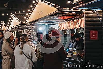 People order food from Steak & Chips stall at Southbank Centre Winter Market, London, UK Editorial Stock Photo