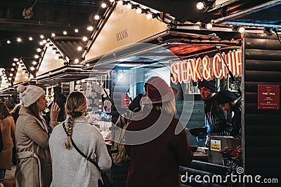 People order food from Steak & Chips stall at Southbank Centre Winter Market, London, UK Editorial Stock Photo