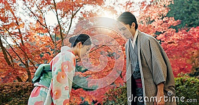 People in park in Japan, bow and traditional clothes with hello, nature and sunshine with respect and culture. Couple Stock Photo
