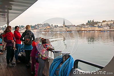 People on a passenger boat on Lake Lucerne with Lucerne city in the back Editorial Stock Photo