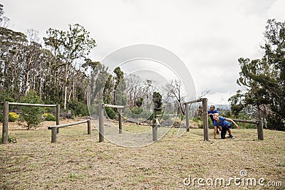 People passing through hurdles during obstacle course Stock Photo