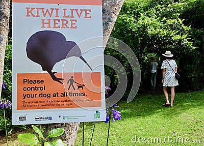 People passing by Kiwi live here sign in a public park in Northland New Zealand Editorial Stock Photo