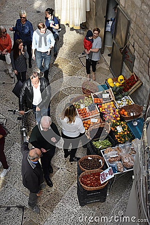 People passing by a street stall full of fruit and vegetables in Bari, Italy Editorial Stock Photo