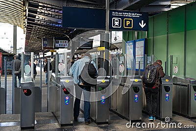 People passing ticket turnstiles to train platforms Paris Editorial Stock Photo