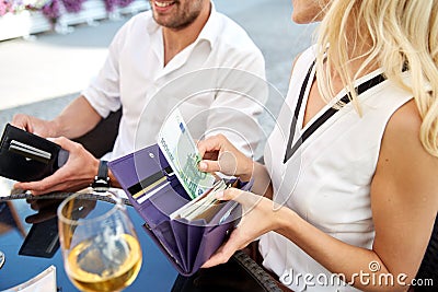 couple sharing bill with cash money at restaurant Stock Photo