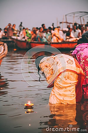 people perform ritual puja at dawn in the Ganges River Editorial Stock Photo