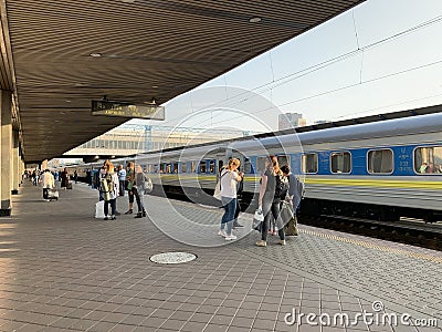 People on the platform of the station are waiting for the train. Men and women meet an approaching train. Concept: tourism, rail Editorial Stock Photo