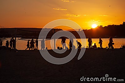 People play volleyball on the beach during the sunset Stock Photo