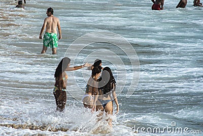 People at Porto da Barra beach entering the sea of intense waves. Salvador, Bahia, Brazil Editorial Stock Photo